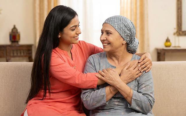 A touching photo of a woman with breast cancer and her daughter, both smiling, sharing a warm embrace, symbolizing hope and resilience during cancer treatment.